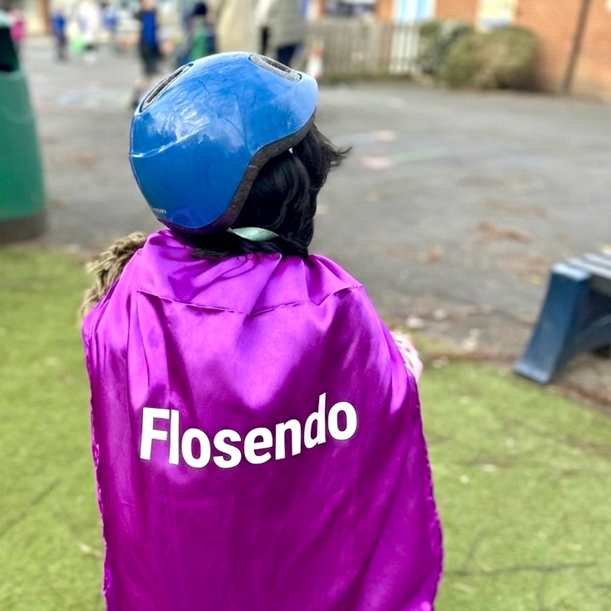 A Flosendo student wearing a purple Flosendo cape in the playground